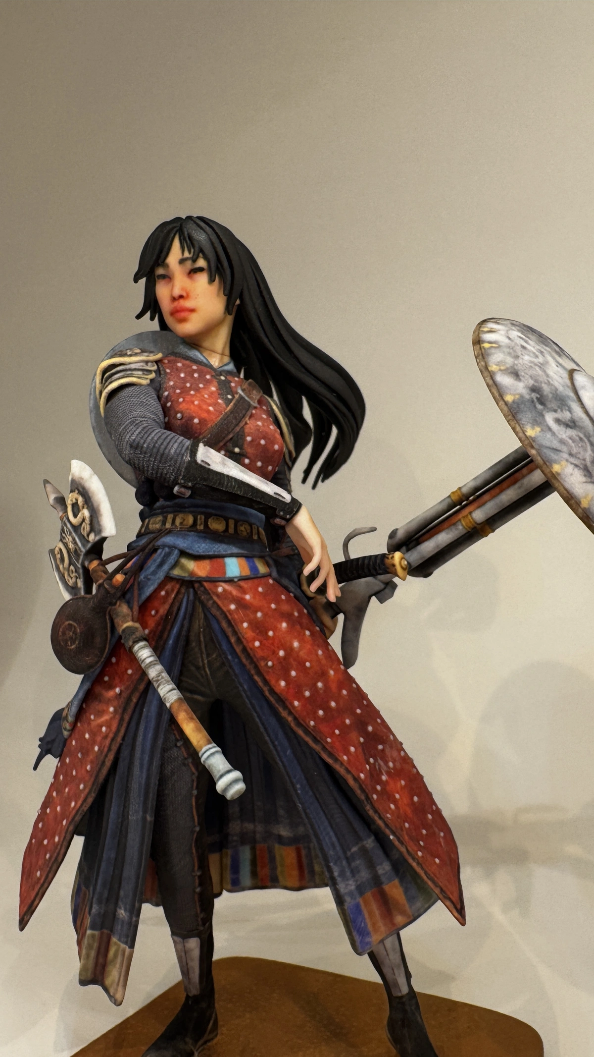 Side close-up product photo of the Dragon Warrior figurine showing armour, textile colour, and weapon detail